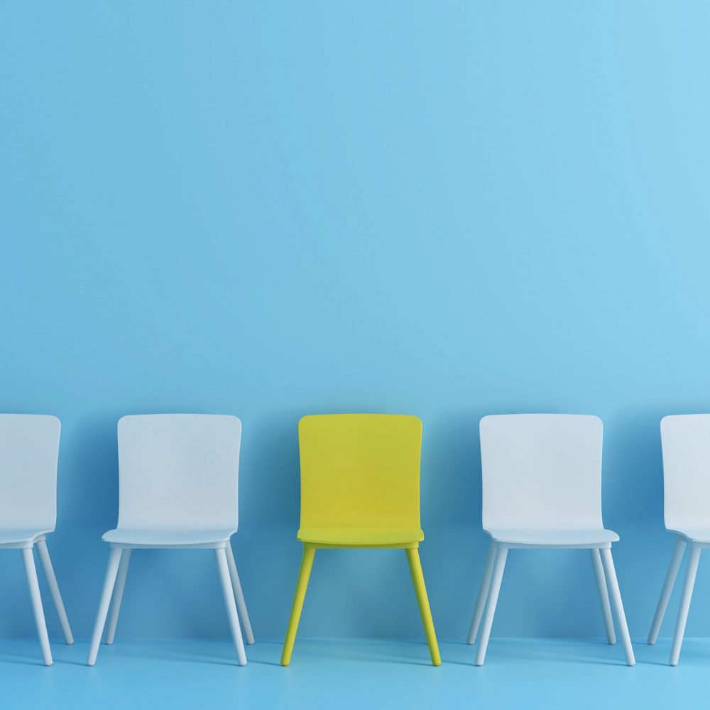 outstanding yellow chair among light blue chair. Chairs with one odd one out in light blue color room.